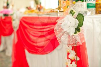 The festive table decorated with a red and white fabric.