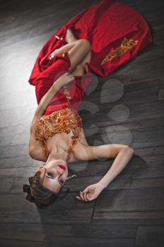 The woman in a red dress on a floor.