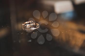 Background from glass and wedding rings.