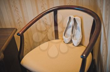 White shoes on a beige chair.