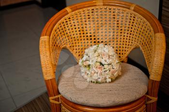Bunch of flowers on a wicker chair.