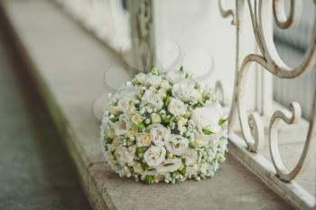 White beautiful bouquet on a handrail.
