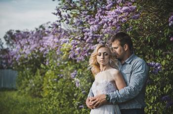 Portraits of a young pair in lilac bushes.