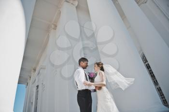 The bride and groom on the background of the white Church.