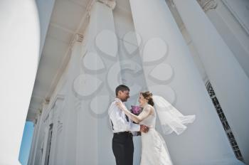 The bride and groom on the background of the white Church.