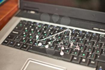 Necklace and earrings on the laptop keyboard.