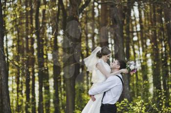 The tender embrace of the newlyweds in the woods.