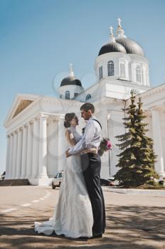 Husband and wife hugging on the background of the Church.
