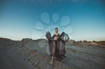 The girl in black linen among sandy dunes.