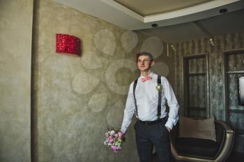 The guy with the bouquet emerges from the darkness of the room.