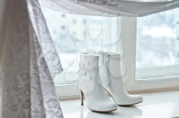 White beautiful boots on a window sill.
