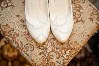 White wedding shoes on a chair.