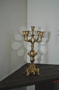 Gold-plated candlestick on the table.