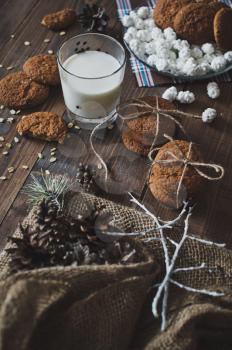 Milk and cookies on wooden table.