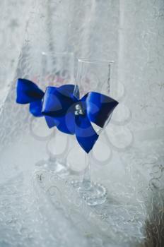 Wedding glasses are decorated with bows.