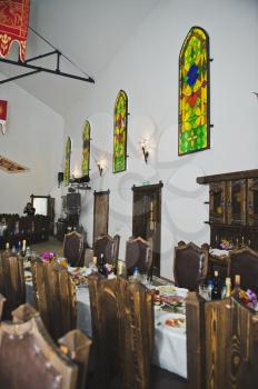 A long festive table with several chairs for guests.