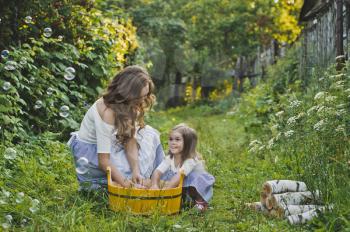 Daughter with mother washing clothes in nature.