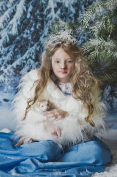 Snow Princess is sitting in the snow around Christmas trees.