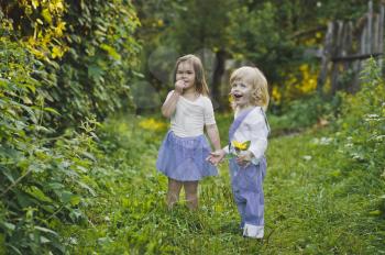 Boy and girl walking in the green garden.