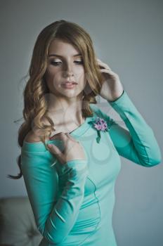 Studio portrait of a girl in a turquoise dress.