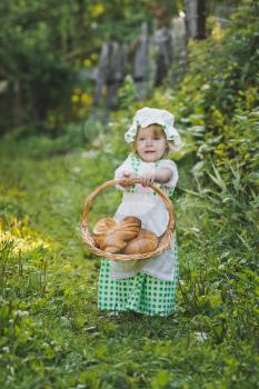 Child with a basket of fresh pastries.