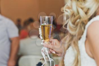 A girl holds a glass of champagne.