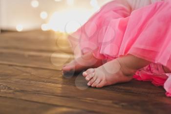 Baby feet on a wooden floor.