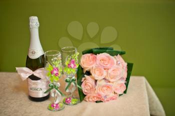 The decorated glasses for wine and a champagne bottle.