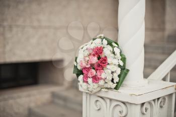 Wedding bouquet on a handrail of a church ladder.