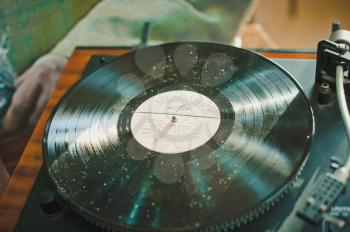 The ancient record player plays music from a vinyl record.