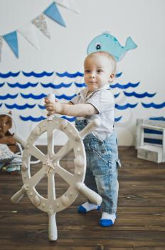 A little boy holds the wheel.