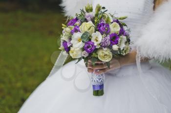 The bride is holding a bouquet of flowers.