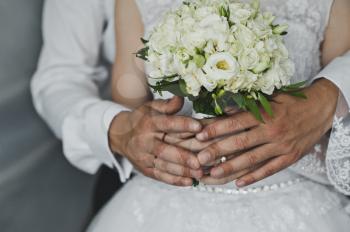 Mans and female hands hold wedding rings.