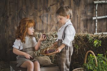 Children play with Easter eggs in the barn.