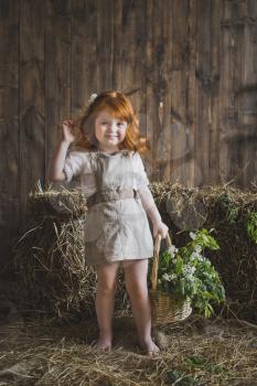 Portrait of a redhead little girl with a basket.
