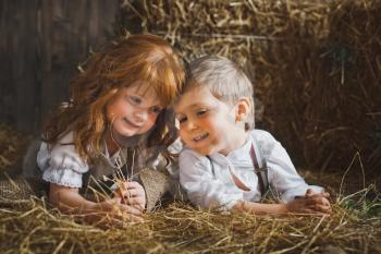 Small children play among the hay.