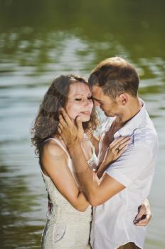 Portrait of a young couple on the shores of green lake.