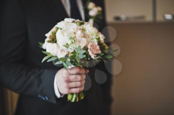 A bouquet of flowers in male hands.