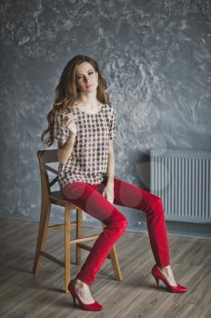 Studio portrait of woman in red jeans.