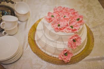 A large wedding cake with pink flowers.
