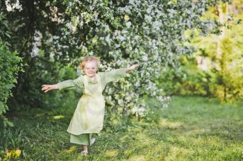 Happy girl running in the garden.