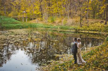 The couple dream of the future standing on the shore of fall lake.
