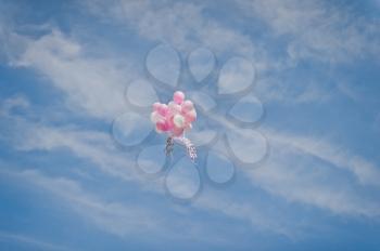 White and pink balloons in the sky.