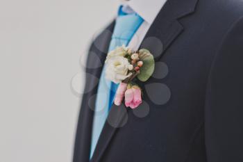 Beautiful flower on his lapel as a decoration.