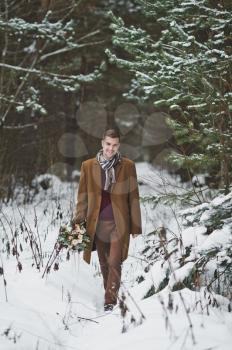 Portrait of business man on the background of winter pine forest.