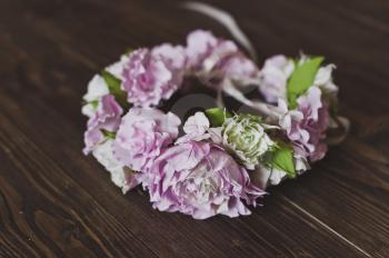 A wreath of flowers on the wooden table.
