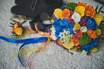Bright multicolored bouquet and mens accessories on white background.