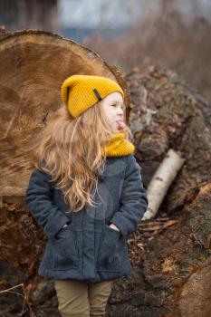 Portrait of a child on a background of a fallen tree.