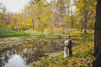 Couple on the shore of the autumn pond.