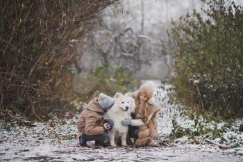 Boy and girl gently petting your beloved Samoyed.